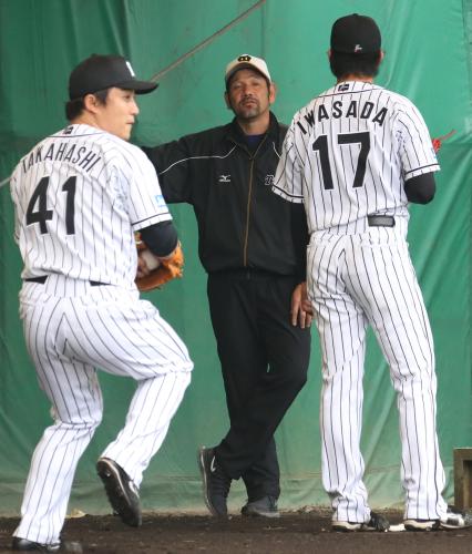 ２月１２日、下柳臨時コーチはブルペンで投球練習中の岩貞（右）にアドバイスする