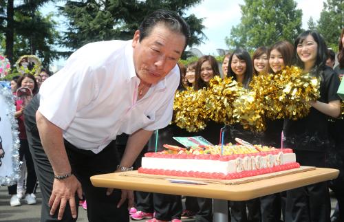 誕生日を迎えた梨田監督は球団職員らに囲まれケーキに立てられたローソクの火を消す