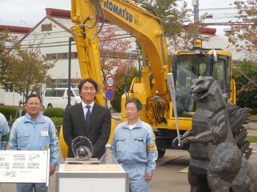 コマツの向上を訪問し、来場記念の鋳造ゴジラ像の横で記念撮影する松井秀喜氏