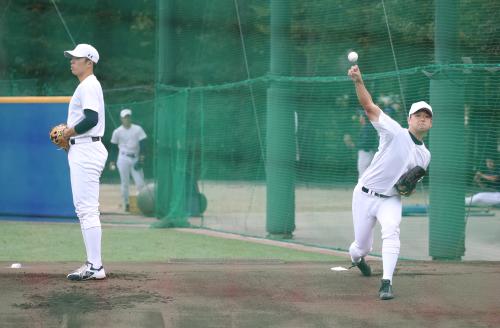 ブルペンで投球練習する創価大・池田（右）と田中