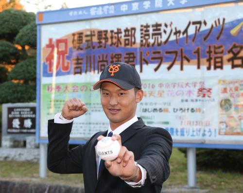 指名あいさつを受けた吉川は学校に掲示されたポスターの前でポーズを決める