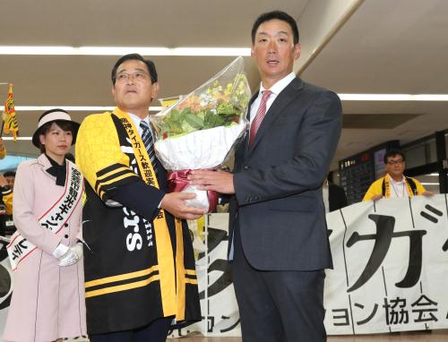 秋季キャンプで高知入りした金本監督は横山安芸市長（左）から花束を受け取る