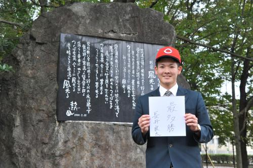 さだまさし作詞の校歌が刻まれた石碑の前で色紙に将来目標を書いた広島ドラフト６位のつくば秀英・長井良太