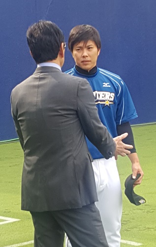 投球練習を終えた公文（右）と話をする日本ハム・栗山監督