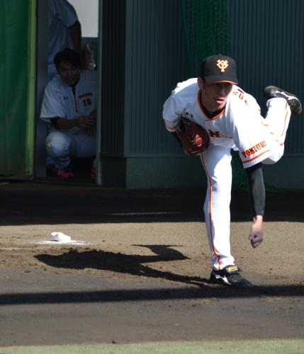 ブルペンで投球練習する巨人・吉川光。後ろで見つめるのは杉内