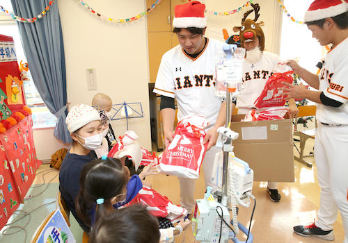 東海大学医学部付属病院を訪れ、プレゼントを渡す巨人・菅野。後方は左から橋本到、辻