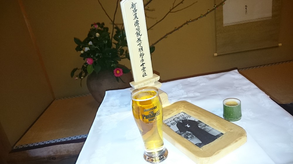 四十九日法要後の会食では、小島昭男さんの位牌に好きだったビールが供えられた。遺影は１９７２年１月２日、父親譲りの紋付きで出勤したスタジオでの写真。