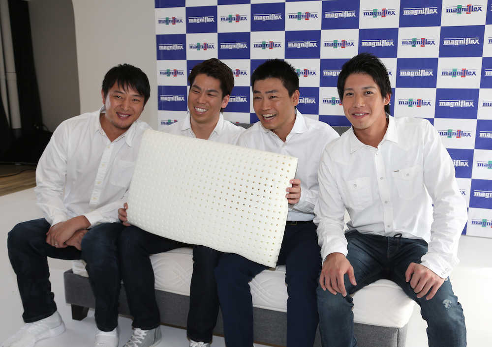 ＣＭ撮影後にマニフレックス社のベットに腰掛け枕を手に笑顔を見せる（左から）岩隈、前田、青木、山田