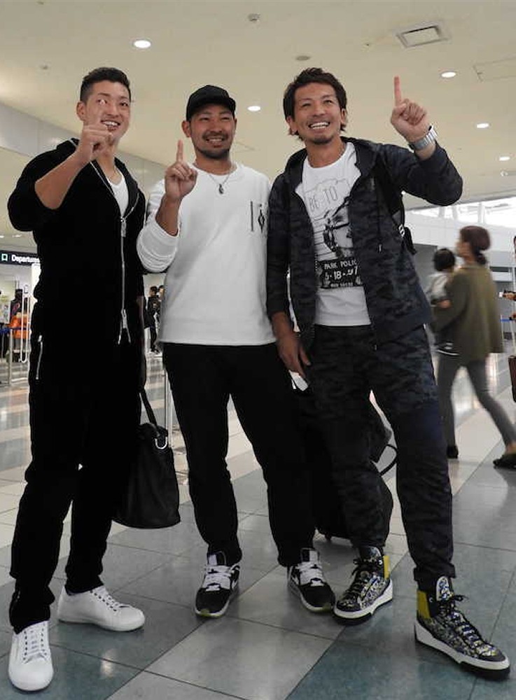 グアム自主トレへ出発するソフトバンク・松田（右）は古沢（左）、オリックス・宮崎と一緒に「１（ワン）ダホー！」のポーズで決める　　　