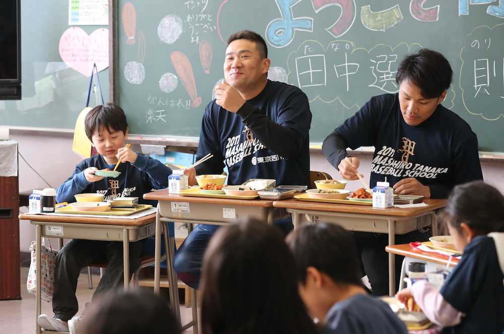 岡田小学校を訪問した田中（左）は則本と一緒に児童たちと給食を食べる