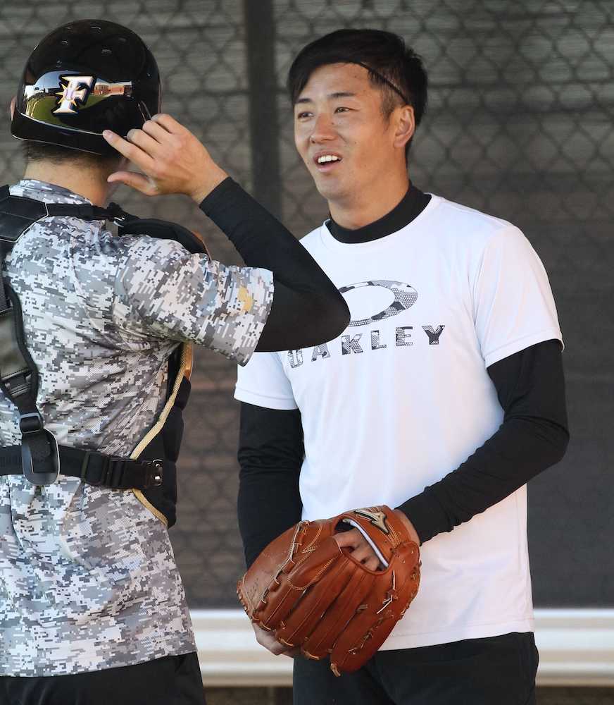 投球練習を終え、捕手・清水優心（右）と笑顔で話す斎藤佑樹