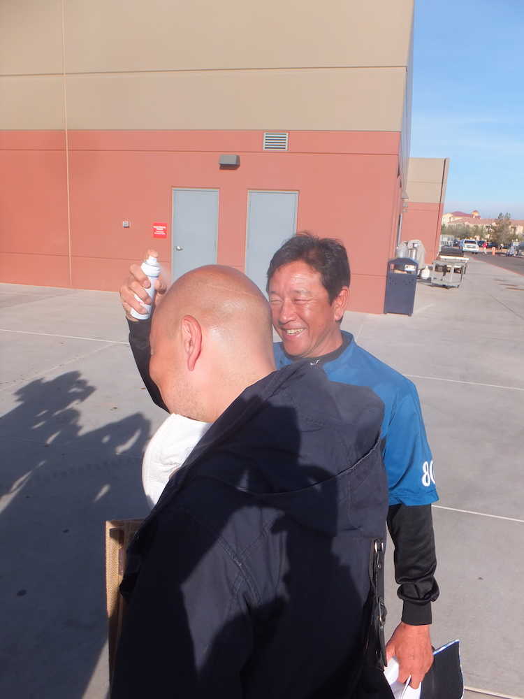 アリゾナ州ピオリアで報道陣に日焼け防止のスプレーをかける日本ハム・栗山監督
