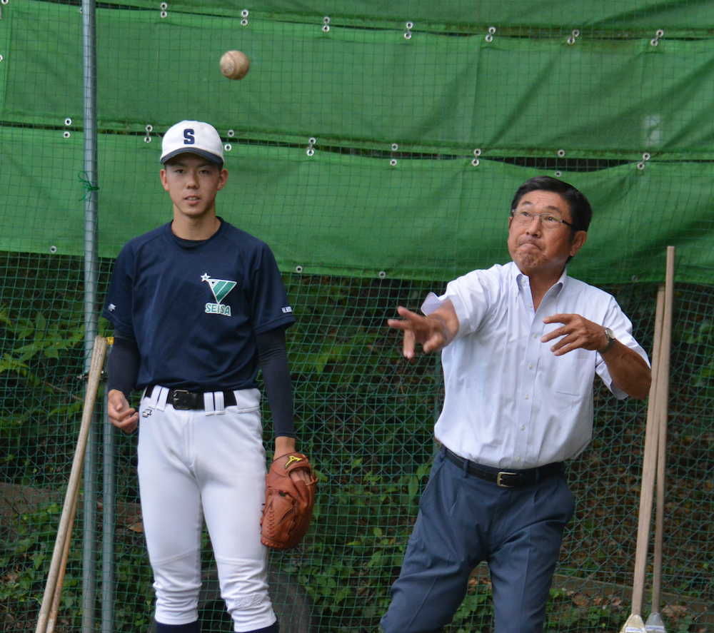 土屋監督（右）からパームボールを教わる星槎国際湘南の本田