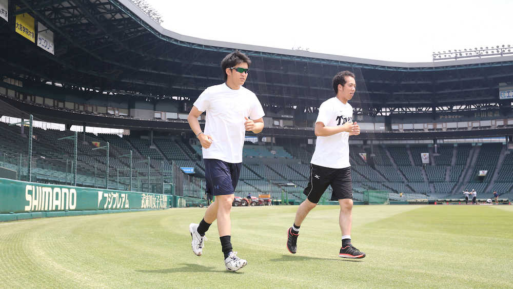 甲子園球場でランニングする岩貞（左）と青柳