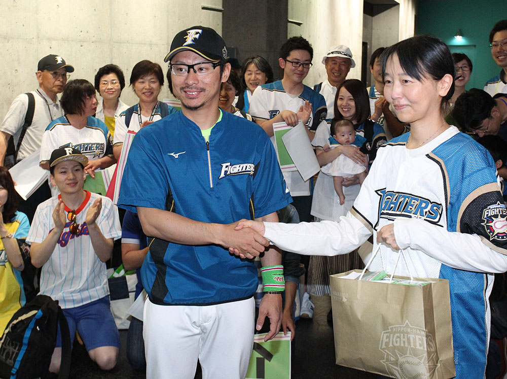 招待したファンと笑顔で握手する日本ハム・谷元