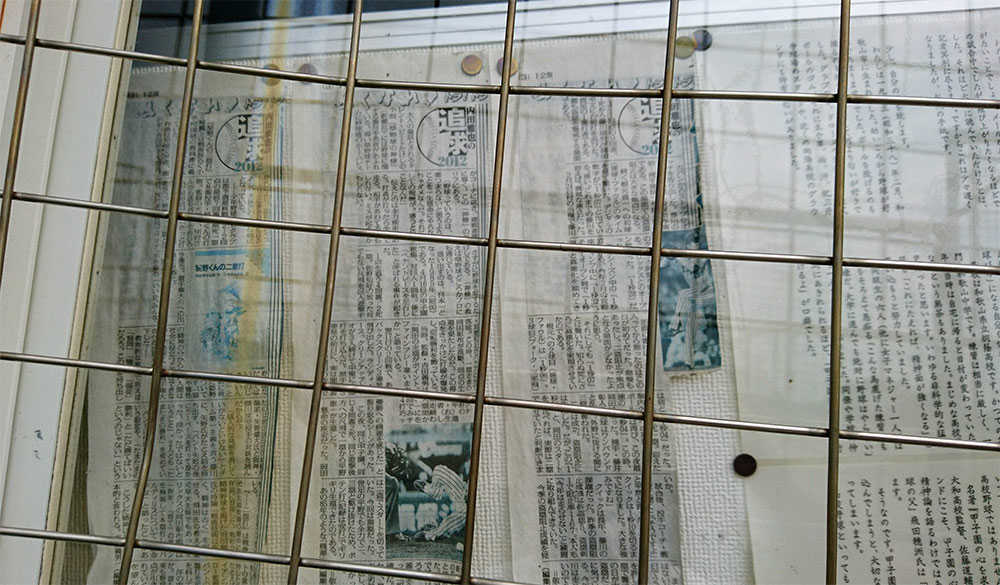 玉野光南監督室の窓に掲示されている『内田雅也の追球』紙面と手紙