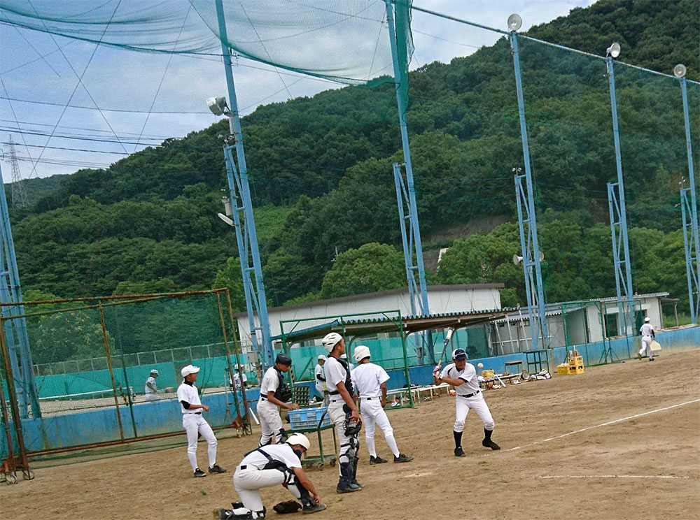 緑に囲まれたグラウンドで練習する玉野光南。ノッカーは田野昌平監督。