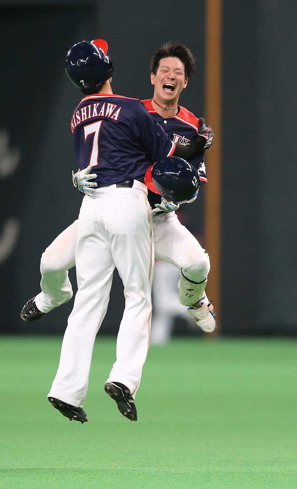 延長１１回１死一、三塁、サヨナラ打を放った松本は西川と抱き合う