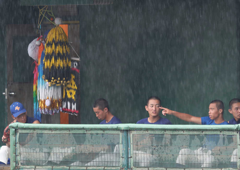 ＜盛岡大付・久慈＞雨の降るグラウンドをベンチから眺める盛岡大付の選手たち