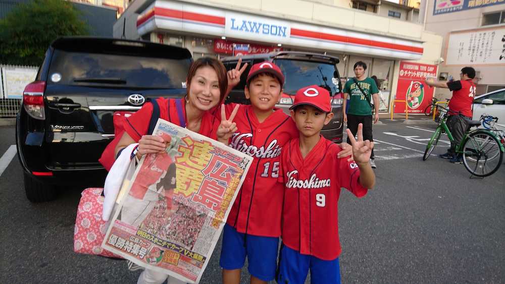 スポニチ号外を手にする広島ファンの家族
