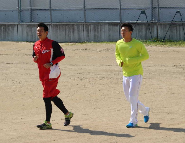 大野練習場で苫米地トレーナー（左）とランニングする広島・鈴木