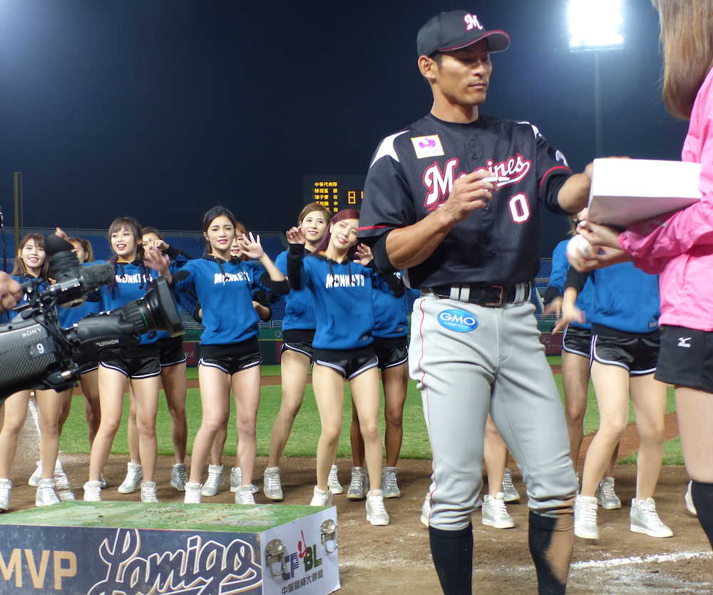 ＜台湾代表・ロッテ＞ＭＶＰに選ばれたロッテ・荻野はラミガールズがダンスをする前でボールにサインを書く