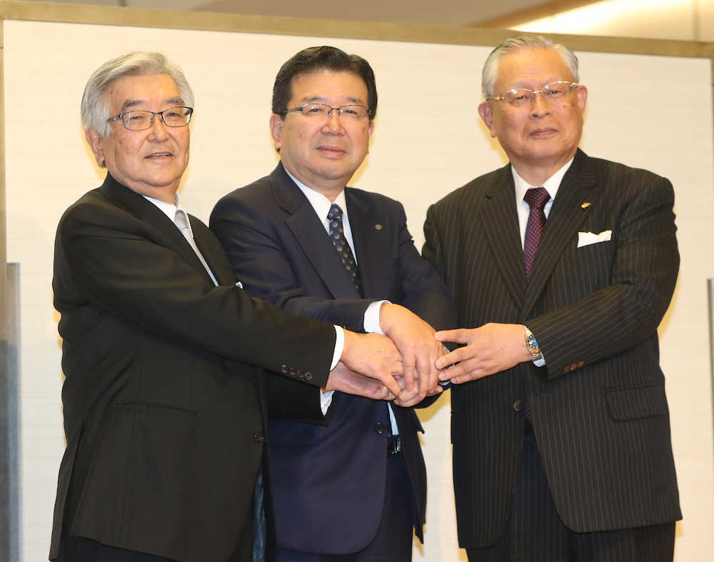 会見の最後に握手する（左から）斉藤新コミッショナー、日本ハム・末沢オーナー会議議長、前コミッショナーの熊崎氏