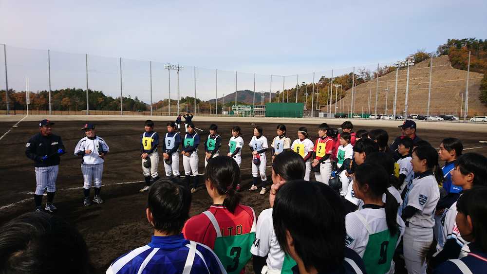 女子野球日本代表・橘田恵監督（左から２人目）の話を聞く選手たち。右奥は木戸克彦ヘッドコーチ（１１月２５日、履正社箕面グラウンド）