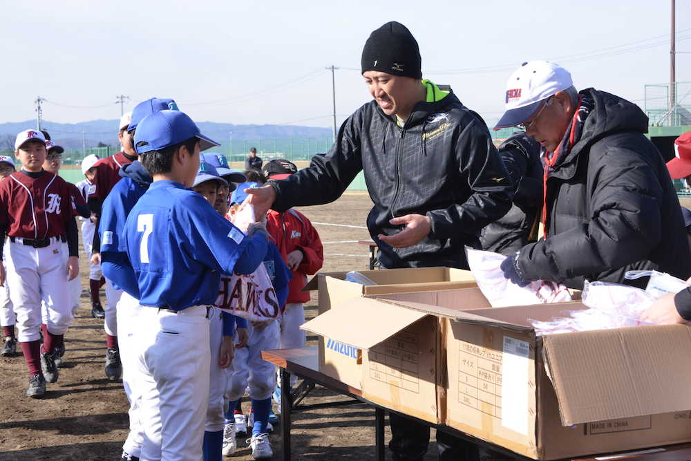 野球教室の終わりに、記念品を渡して野球少年たちと握手を交わす内川