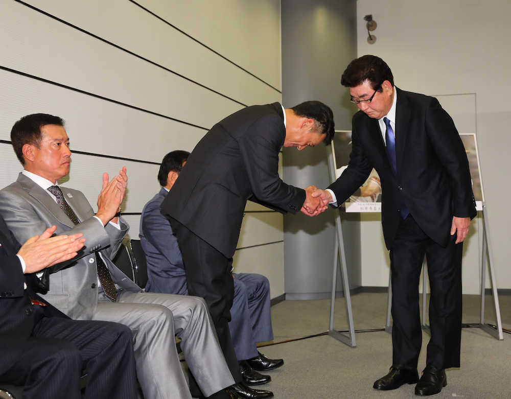 山本氏（右）と握手を交わす阪神・金本監督（中央）