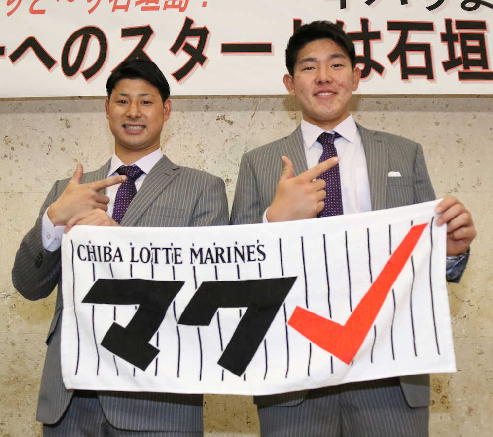 スローガンのタオルを手に「マクレ」のポーズをとる藤岡（左）と安田