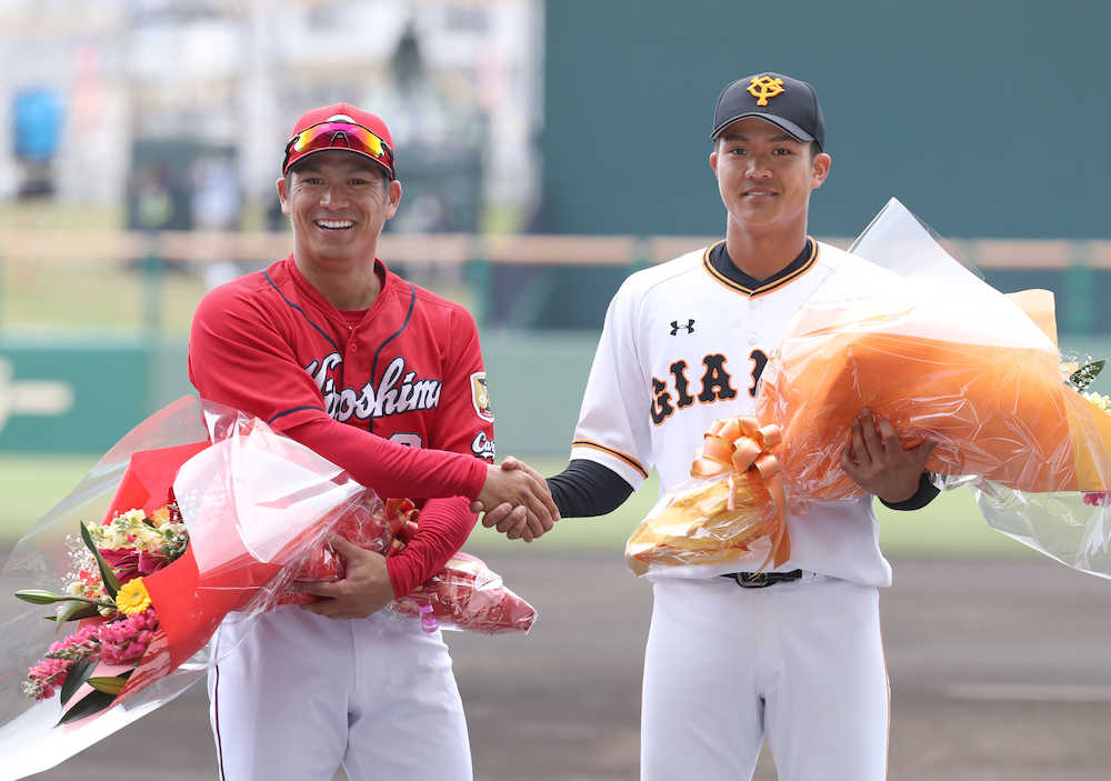 ＜巨・広＞試合前の花束贈呈で兄の広島・田中（左）と巨人・田中俊は笑顔で握手