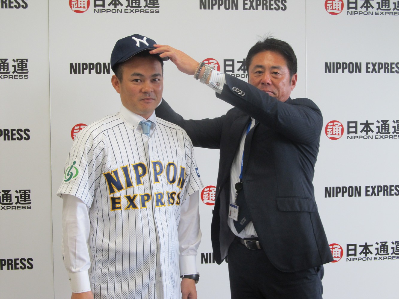 兼任コーチとして日本通運に復帰し、入団会見で藪監督（右）に帽子をかぶせてもらう武田久
