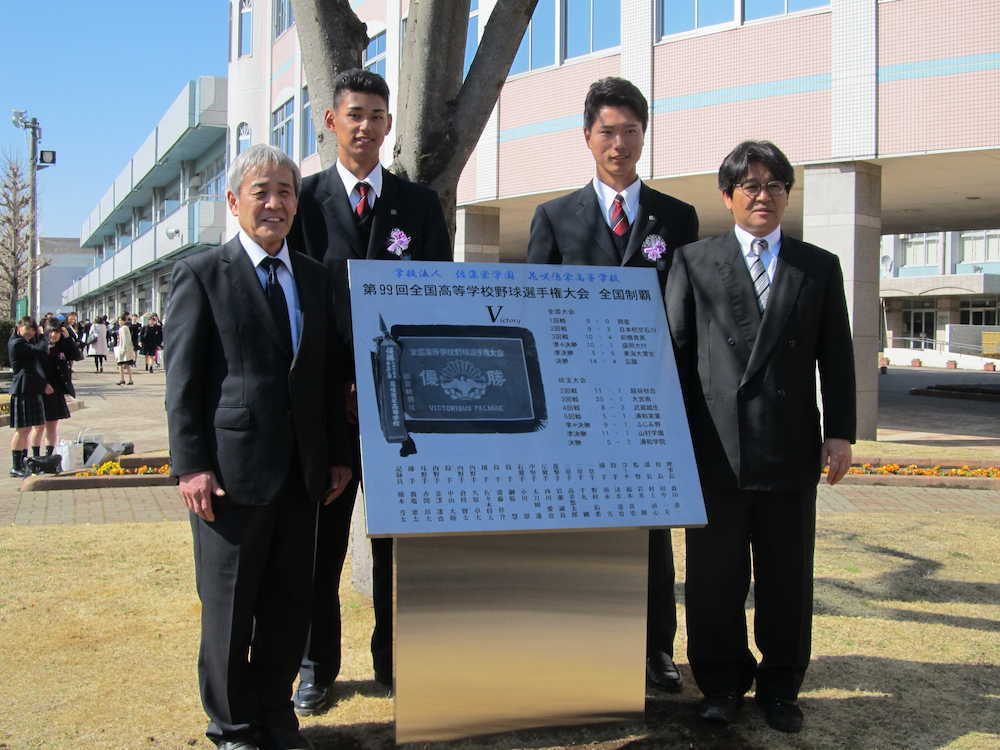記念碑を寄贈し、岩井監督（右端）らと記念撮影する西武・西川（左から２人目）と中日・清水（同３人目）