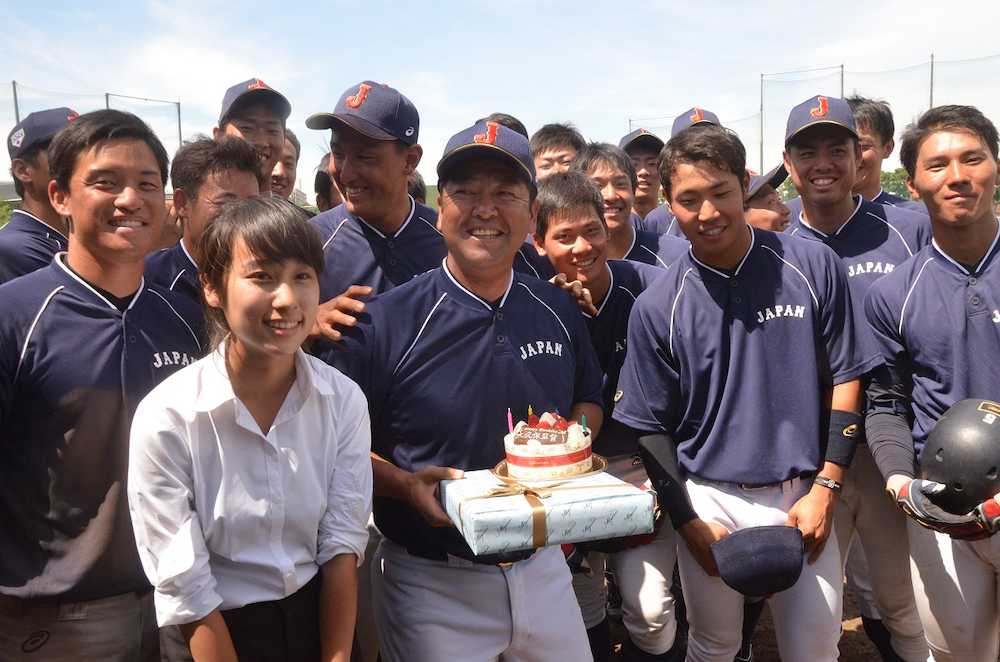 サプライズで誕生日ケーキを贈られ笑顔の侍ジャパン大学代表・大久保監督（中央）。左は小林マネジャー