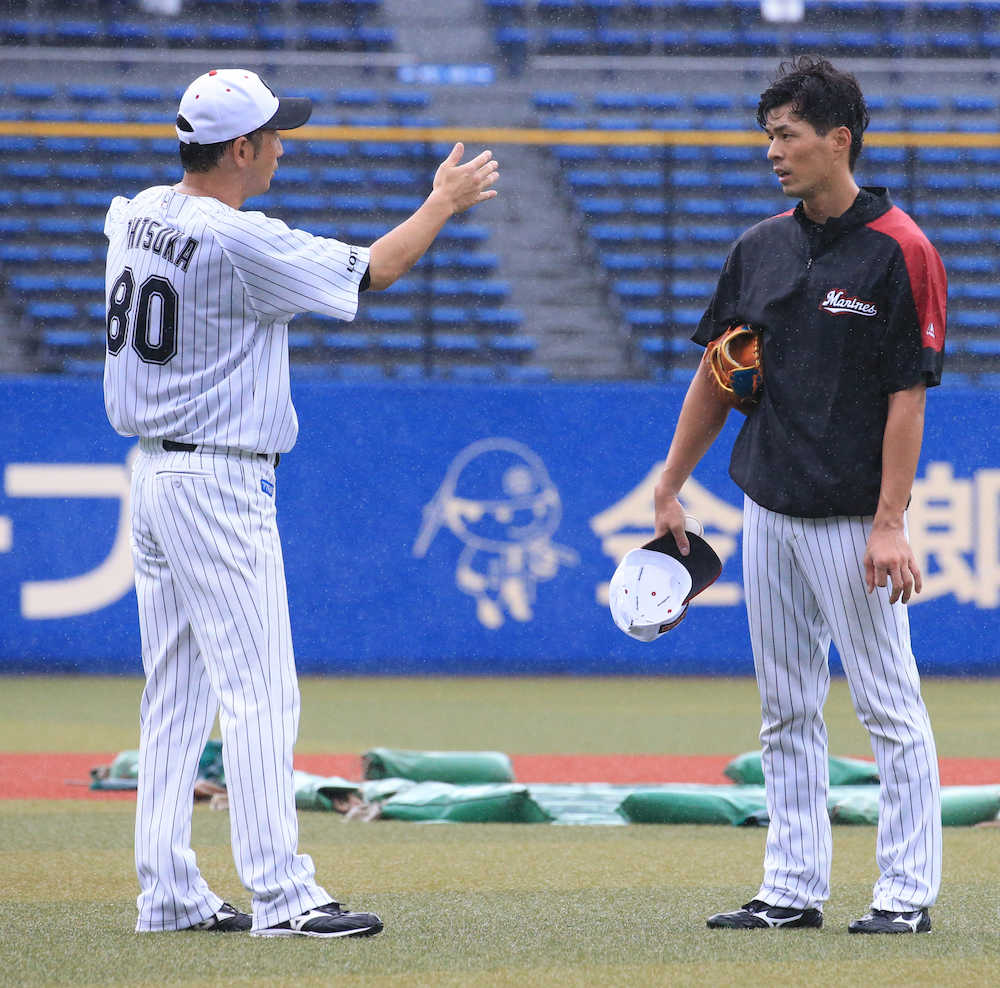 大塚外野守備走塁コーチ（左）からアドバイスを受ける岡（撮影・森沢裕）
