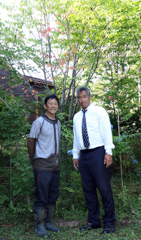 「栗の木ファーム」を訪れた木田ＧＭ補佐と一緒に桜の木の前で記念写真に収まった栗山監督（左）（撮影・高橋茂夫）