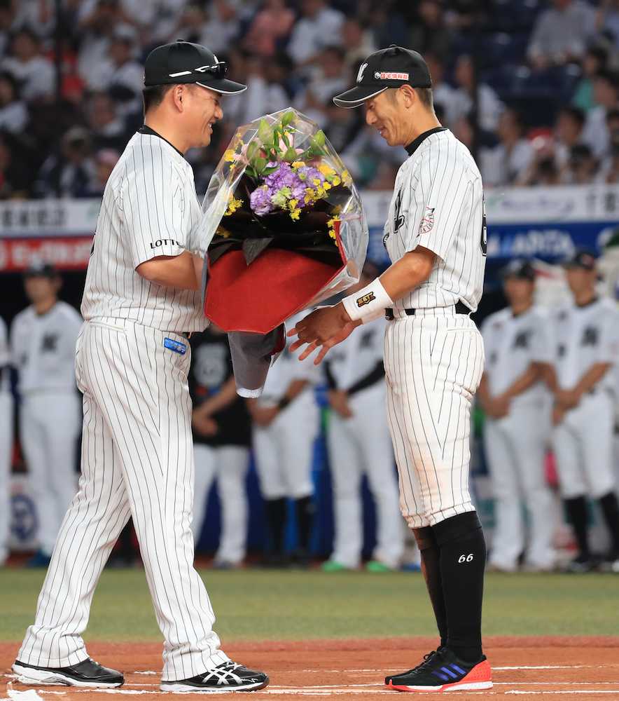 引退セレモニーで、井口監督（左）から花束を渡される岡田（撮影・篠原岳夫）