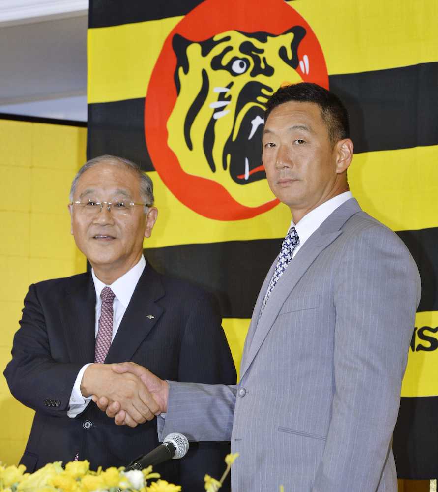 ２０１５年１０月、金本知憲監督の就任記者会見で握手する阪神の坂井信也オーナー（左）