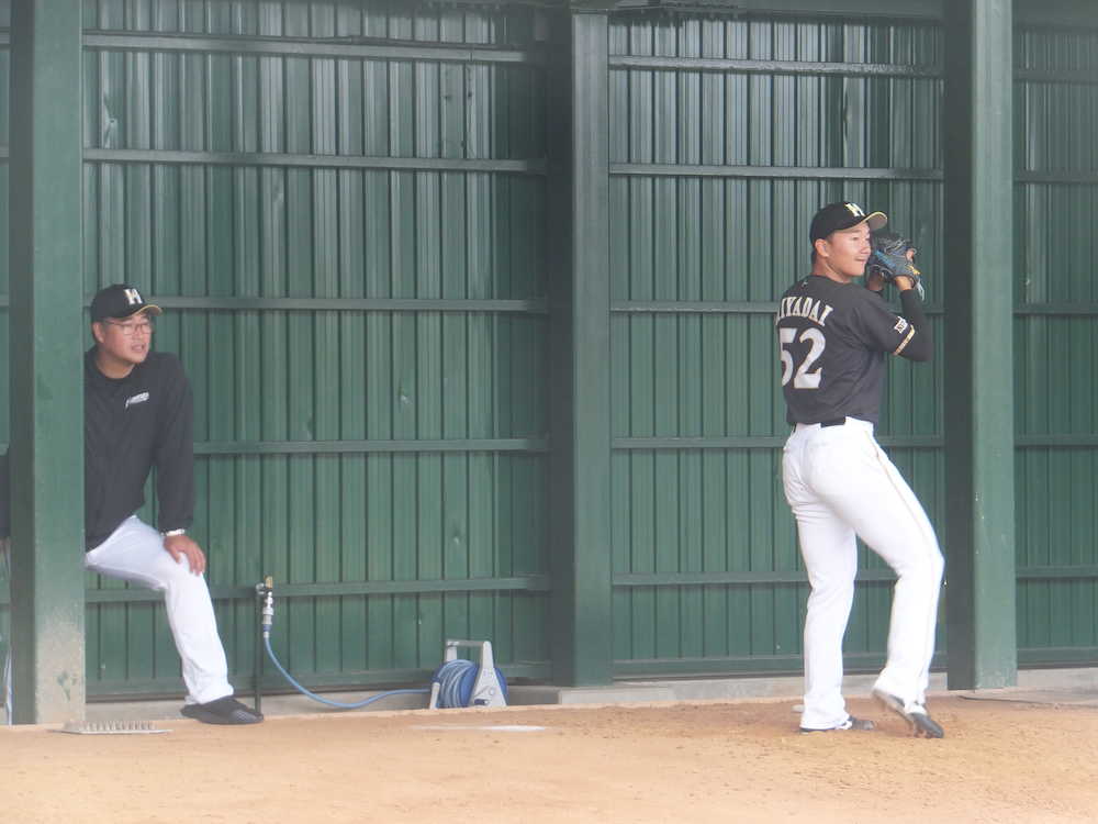 木田チーフ投手コーチ（左）が見守る中でブルペン投球を行う日本ハム・宮台