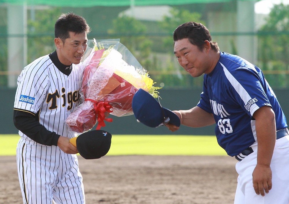 惜別試合のセレモニーで中日・中村コーチから花束を受け取る矢野（左）