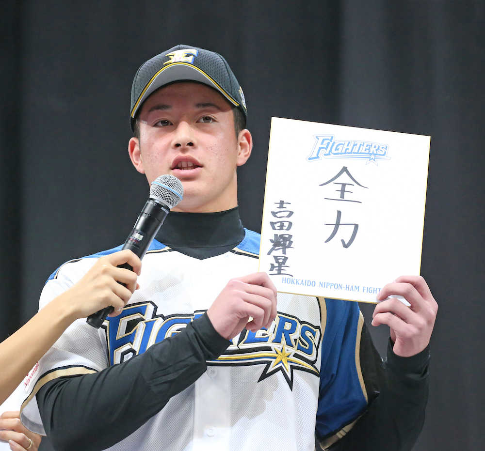新入団選手として紹介された吉田輝は「全力」と抱負を色紙に書いて披露する　（撮影・西川祐介）