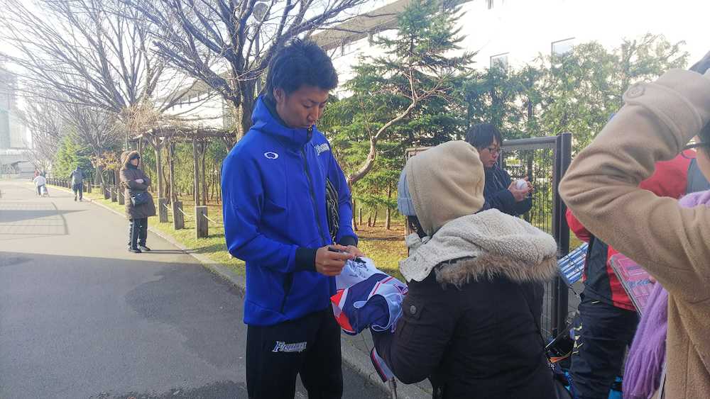 札幌市内の室内練習場での自主トレ後、集まったファンにサインする日本ハム・浦野