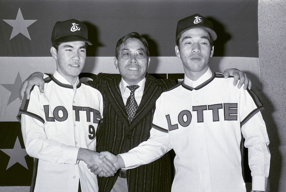 ロッテに入団した３位指名の東芝府中・落合博満内野手（右）とドラフト外の米沢商・江本裕人（左）中央は山内監督