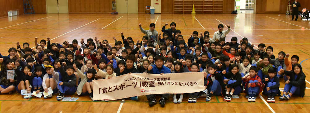 井野小学校の児童らと記念写真に納まる中島