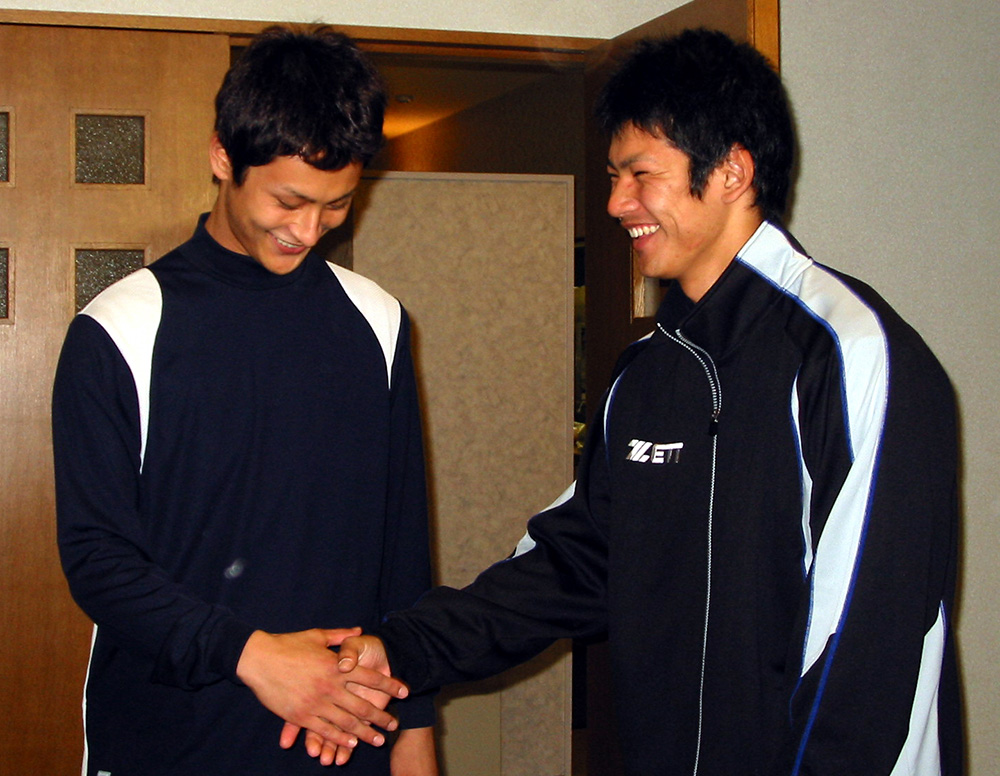 ２００４年１２月、日本ハム入団を前に握手するダルビッシュ（左）と鵜久森