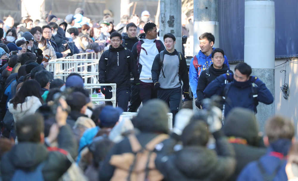 大勢のファンが見つめる中、球場に向かう吉田輝（左から４人目）（撮影・沢田　明徳）