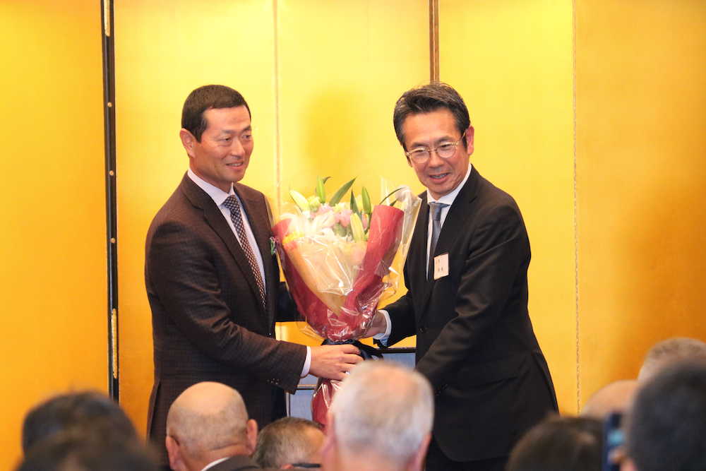 ＰＬ学園ＯＢ会の新会長に就任し、前会長の鶴岡秀樹氏（右）に花束を手渡す、桑田真澄氏