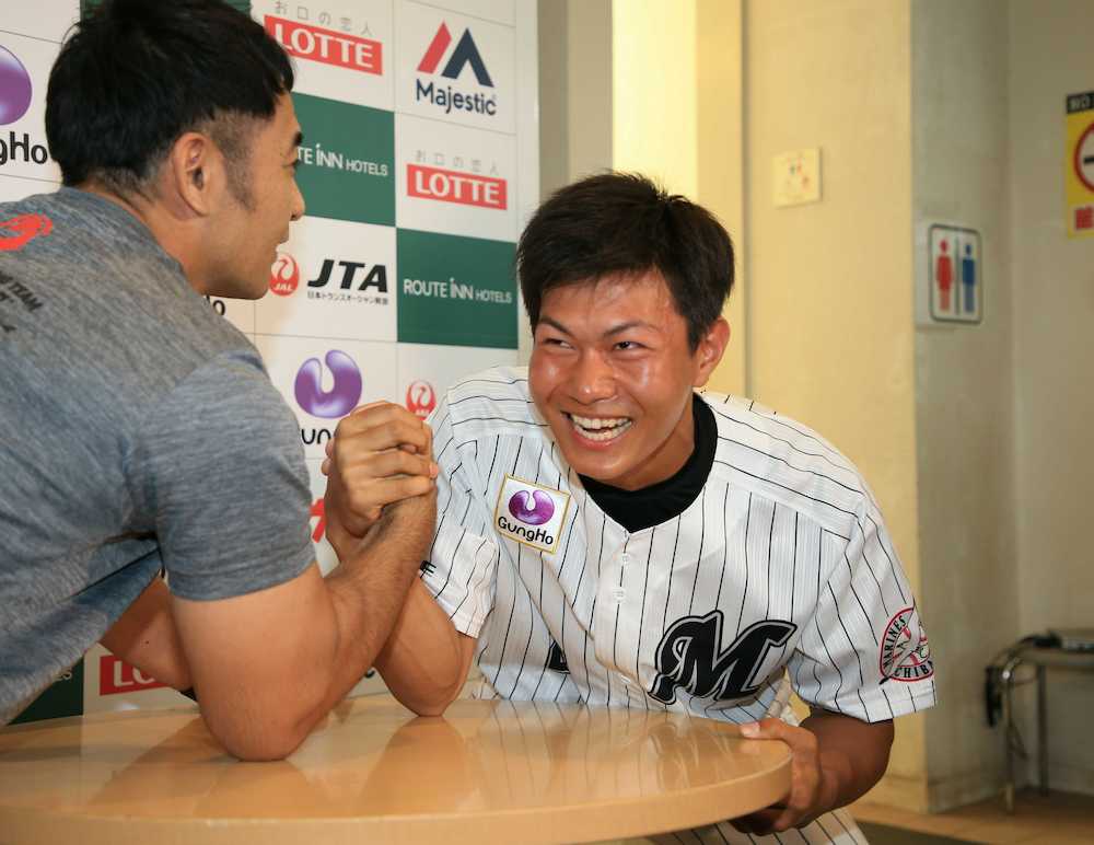 ＜ロッテキャンプ＞元日本チャンピオンの石川氏とのアームレスリングに挑み、あまりの強さに苦笑いする藤原