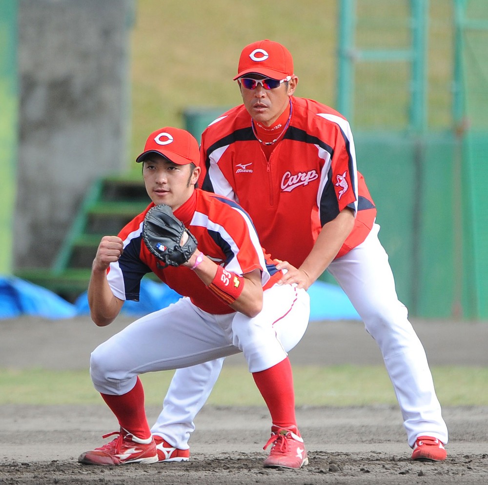 １２年春季キャンプで当時選手兼任野手コーチの石井琢朗（右）から指導を受ける菊池